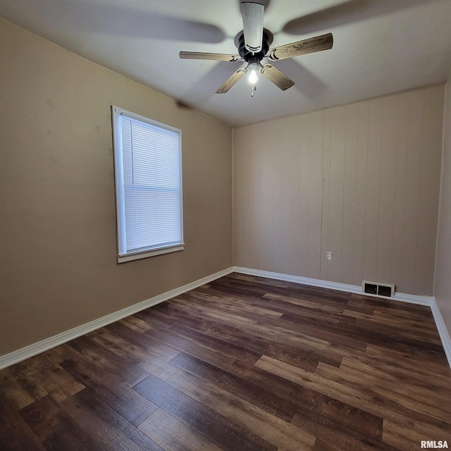 empty room with ceiling fan and dark wood-type flooring