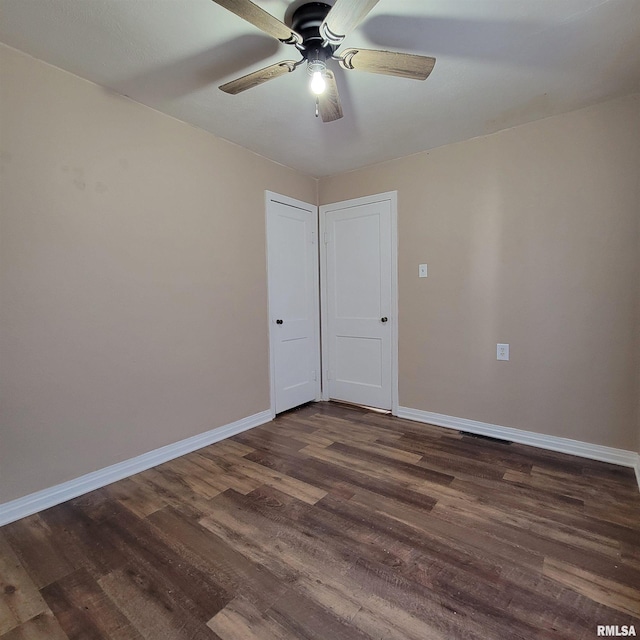 empty room featuring ceiling fan and dark hardwood / wood-style flooring