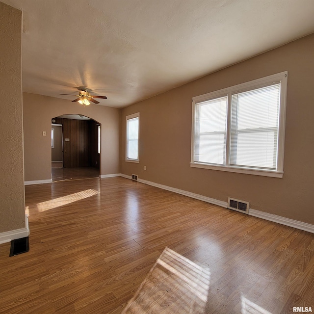 spare room featuring ceiling fan, plenty of natural light, and hardwood / wood-style flooring