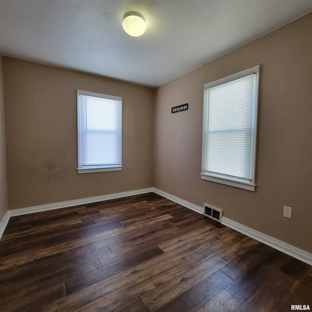 spare room with dark hardwood / wood-style floors