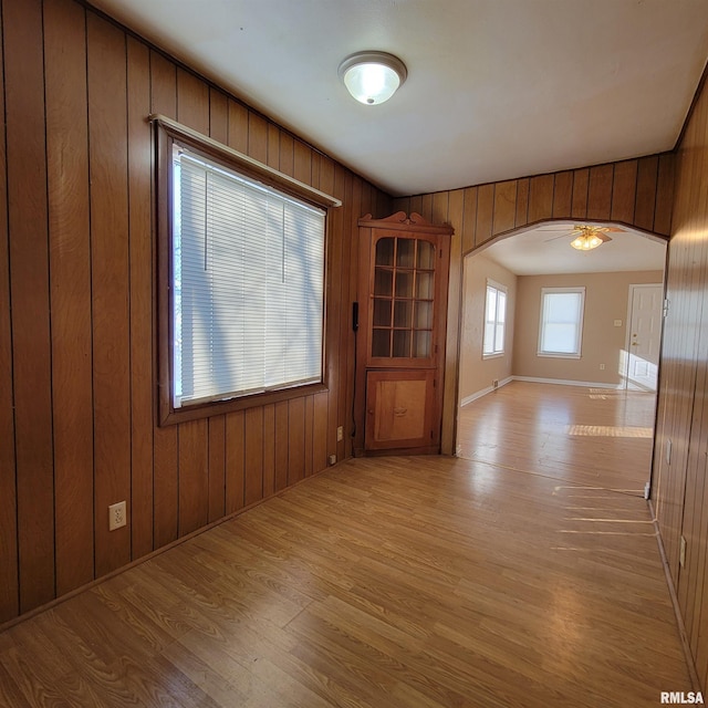 spare room featuring wooden walls and light hardwood / wood-style flooring