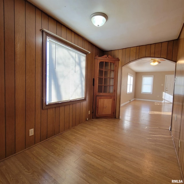 spare room featuring light hardwood / wood-style flooring and wood walls