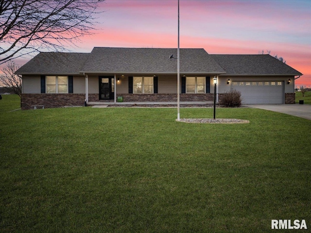 ranch-style home featuring a garage and a lawn