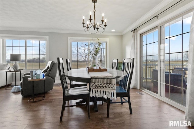 dining area with dark wood-type flooring, ornamental molding, and plenty of natural light