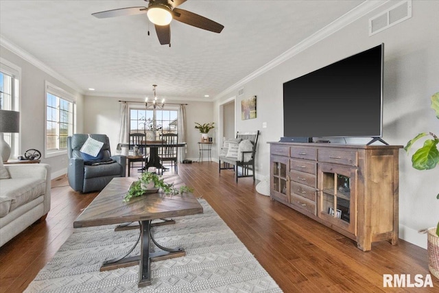 living room featuring ceiling fan with notable chandelier, wood-type flooring, and crown molding