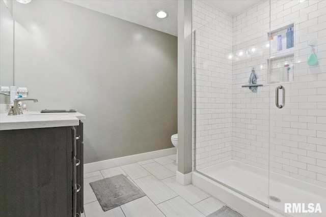 bathroom featuring toilet, vanity, an enclosed shower, and tile patterned floors