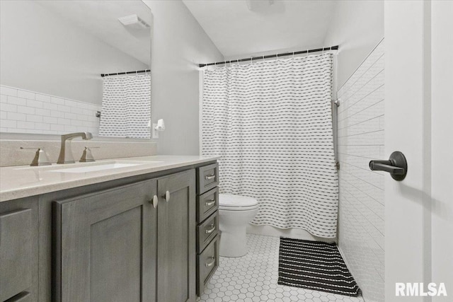 bathroom featuring toilet, vanity, tile patterned flooring, and a shower with curtain