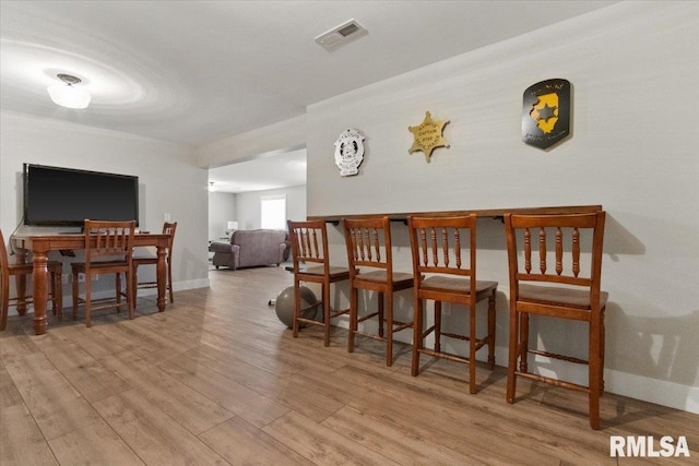 bar with light hardwood / wood-style floors