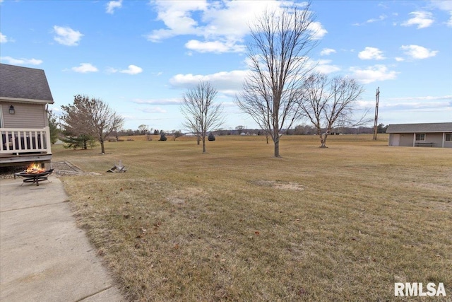 view of yard featuring a rural view and a fire pit