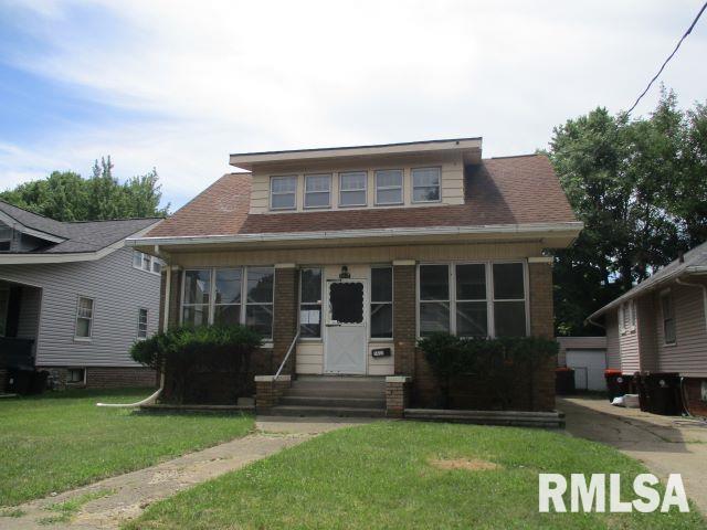 bungalow-style house with a front lawn