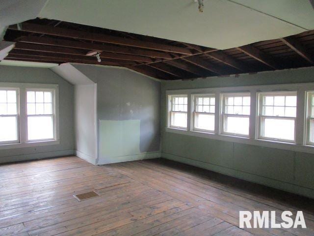 spare room featuring vaulted ceiling and light hardwood / wood-style flooring