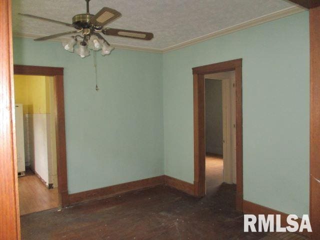 spare room featuring a textured ceiling, dark wood-type flooring, ornamental molding, and ceiling fan