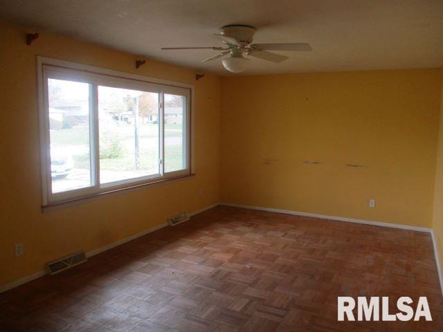 empty room featuring ceiling fan and parquet flooring