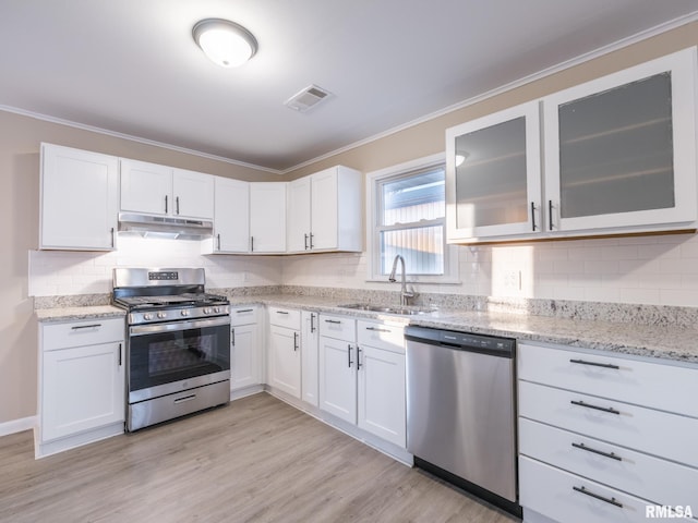 kitchen featuring light stone countertops, sink, stainless steel appliances, and white cabinetry