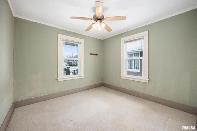 empty room with ceiling fan, ornamental molding, and light colored carpet