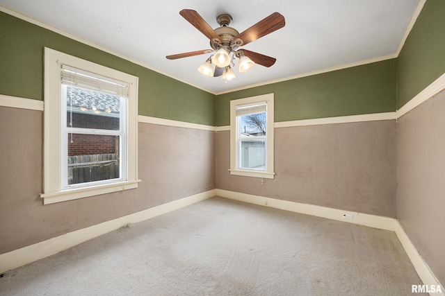 carpeted empty room with ceiling fan and crown molding