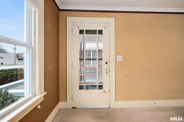 entryway with a wealth of natural light, ornamental molding, and carpet flooring