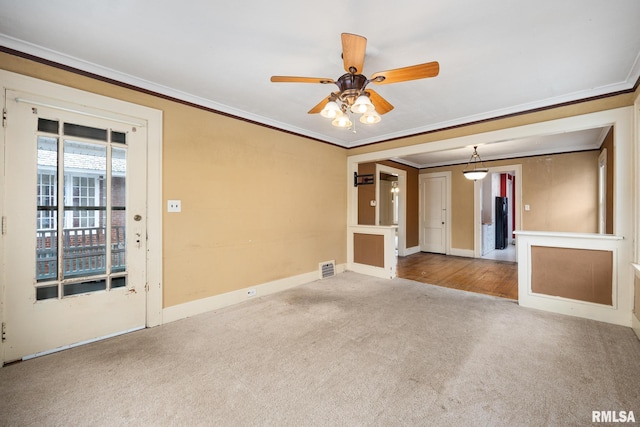 carpeted empty room with ceiling fan and crown molding