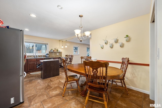 dining room with sink and an inviting chandelier