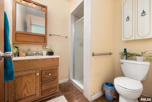 bathroom with toilet, an enclosed shower, and vanity