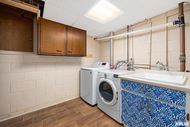 clothes washing area featuring washing machine and clothes dryer and cabinets