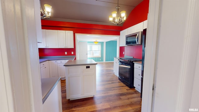 kitchen featuring gas stove, dark hardwood / wood-style floors, vaulted ceiling, white cabinets, and a center island