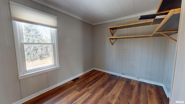 empty room featuring dark hardwood / wood-style flooring and ornamental molding