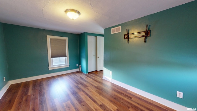 empty room featuring hardwood / wood-style floors and a textured ceiling