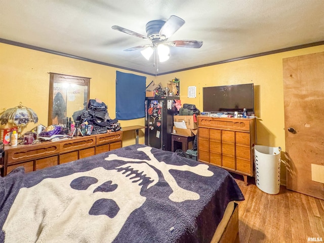 bedroom with ceiling fan, light hardwood / wood-style floors, and ornamental molding