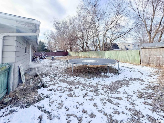 yard covered in snow with a trampoline