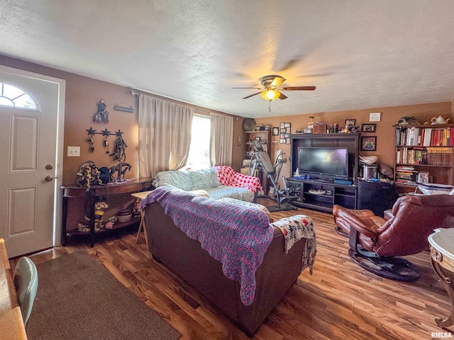 living room with hardwood / wood-style flooring, a textured ceiling, and ceiling fan