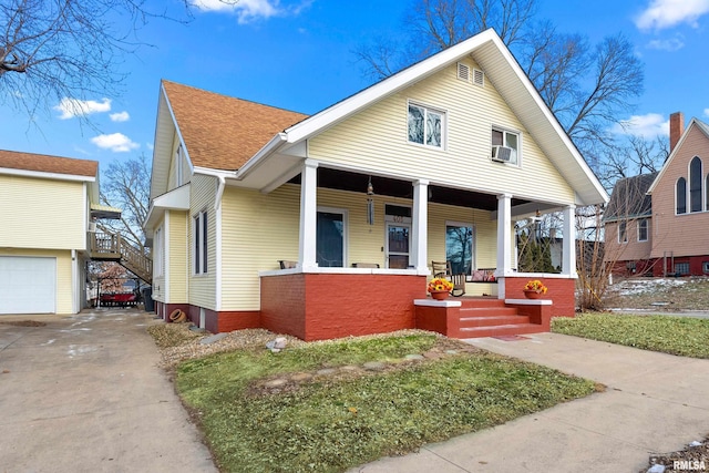 bungalow-style home with a garage and covered porch