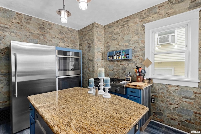 kitchen featuring pendant lighting, sink, blue cabinetry, a kitchen island, and stainless steel appliances