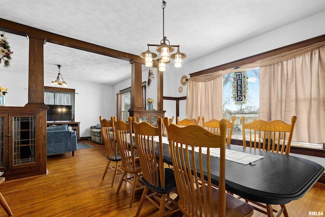 dining space with hardwood / wood-style flooring and a chandelier