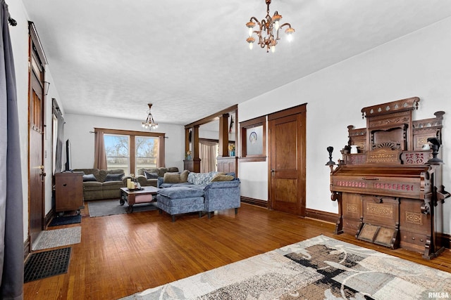 living room featuring dark wood-type flooring and a chandelier