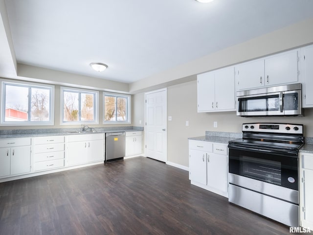 kitchen with sink, white cabinetry, appliances with stainless steel finishes, and dark hardwood / wood-style floors