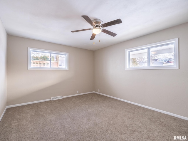 carpeted spare room with ceiling fan