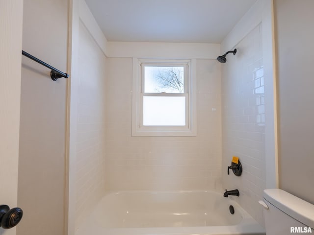 bathroom with toilet and tiled shower / bath