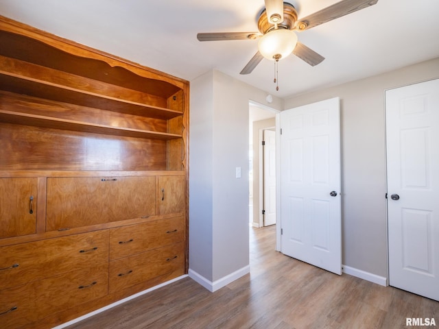 unfurnished bedroom with ceiling fan and hardwood / wood-style flooring