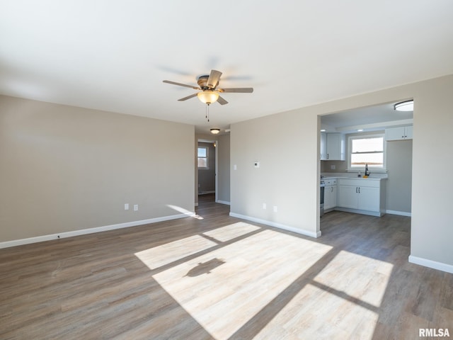 empty room featuring sink, hardwood / wood-style floors, and ceiling fan