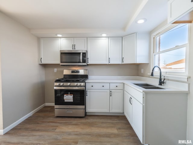 kitchen featuring sink, light hardwood / wood-style floors, white cabinets, and appliances with stainless steel finishes