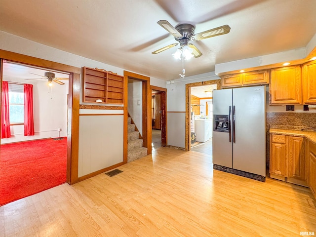 kitchen with washer / clothes dryer, stainless steel fridge, ceiling fan, and light hardwood / wood-style flooring