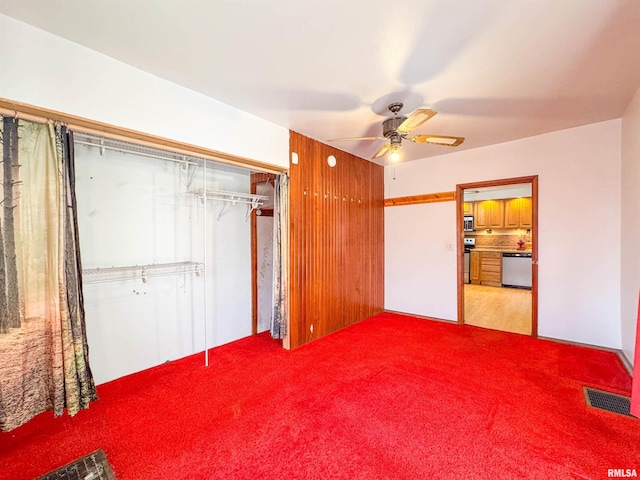 unfurnished bedroom featuring a closet, ceiling fan, and carpet