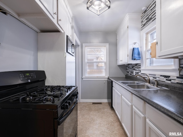 kitchen featuring sink, white cabinetry, black appliances, and plenty of natural light