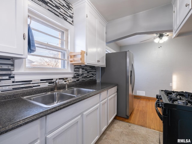 kitchen featuring sink, black gas range oven, white cabinetry, and stainless steel fridge with ice dispenser