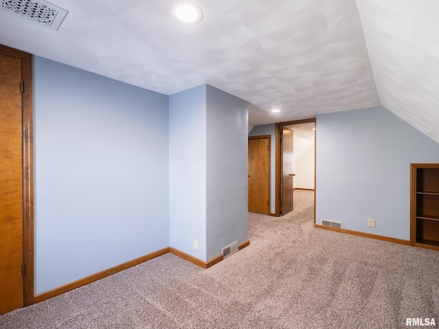 additional living space with vaulted ceiling and light colored carpet