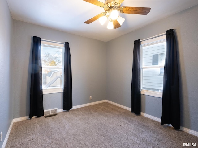 carpeted spare room featuring ceiling fan