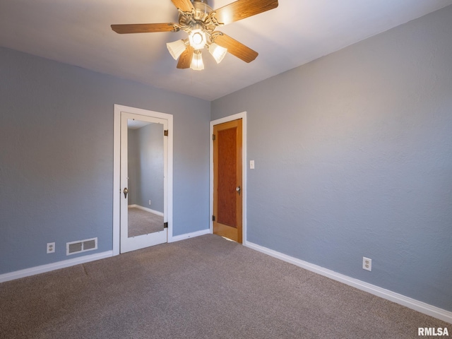 carpeted spare room with ceiling fan