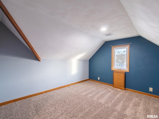 bonus room with carpet flooring and vaulted ceiling