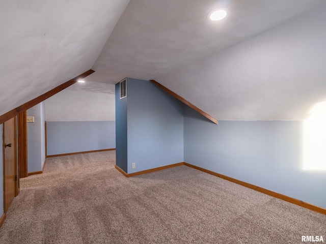 additional living space with carpet floors and lofted ceiling